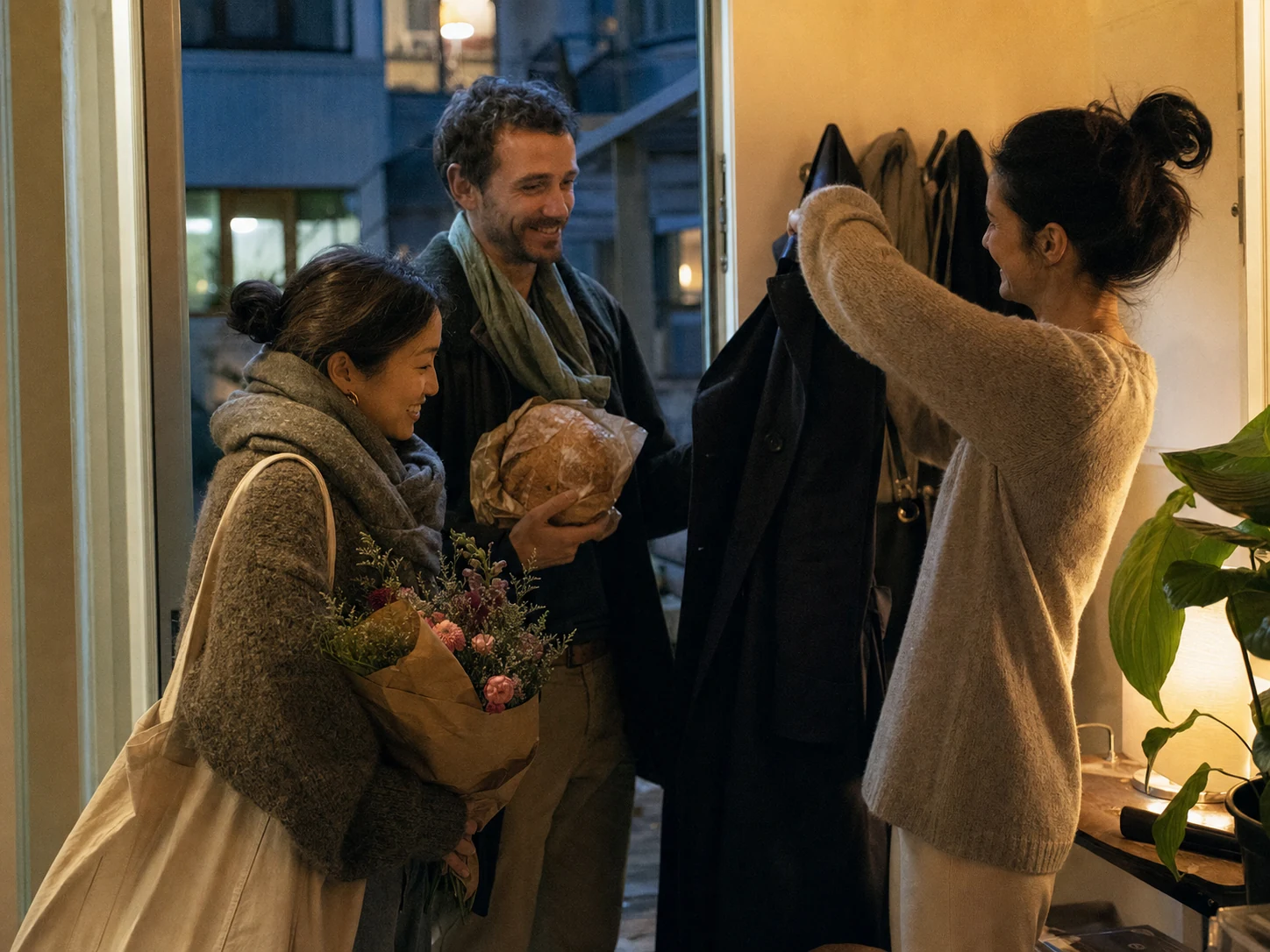 Friends arriving at a home at dusk